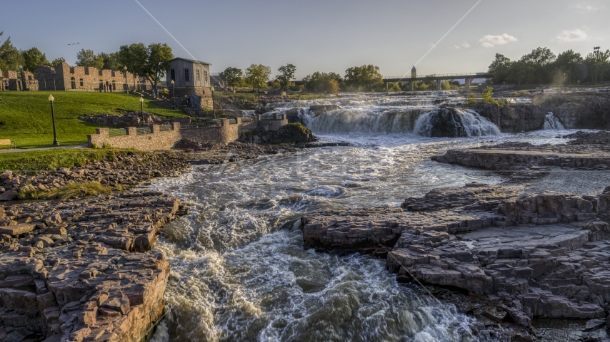A low view of waterfalls at sunset in Sioux Falls, South Dakota Aerial Stock Photo DXP002_176_0005 | Axiom Images
