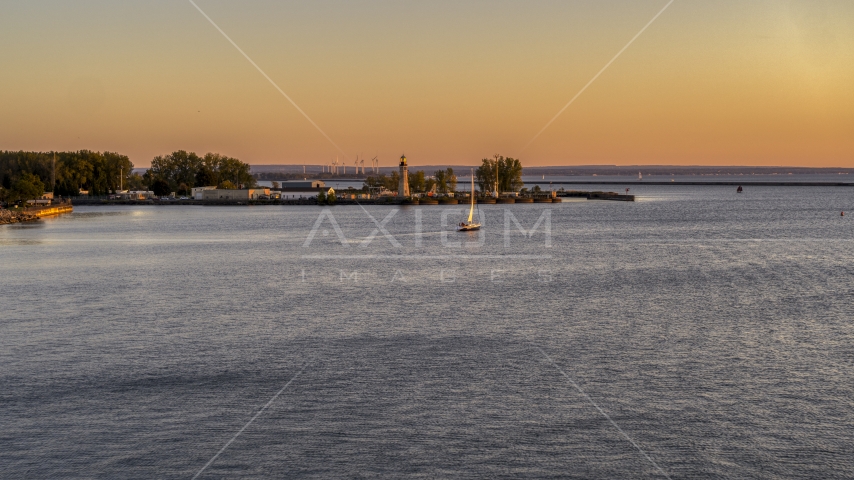 A sailboat on Lake Erie near lighthouse at sunset, Buffalo, New York Aerial Stock Photo DXP002_204_0007 | Axiom Images