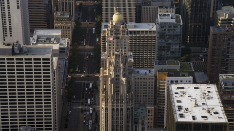 AX0001_118.0000016F - Aerial stock photo of A flag flying at top of Tribune Tower in Downtown Chicago, Illinois