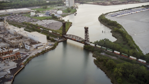 AX0001_171.0000135F - Aerial stock photo of A train crossing a bridge spanning the Calumet River in Hegewisch, Chicago, Illinois