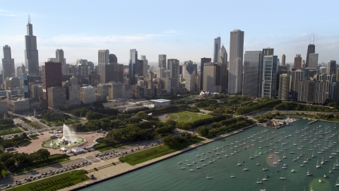 AX0002_005.0000214F - Aerial stock photo of Grant Park and Downtown Chicago skyscrapers near boats in the harbor, Illinois