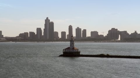 AX0002_048.0000171F - Aerial stock photo of Chicago Harbor Lighthouse, and the Downtown Chicago skyline in the distance, Illinois