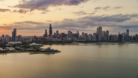 AX0003_029.0000188F - Aerial stock photo of A view of Downtown Chicago skyline and the Adler Planetarium seen from Lake Michigan, at sunset, Illinois