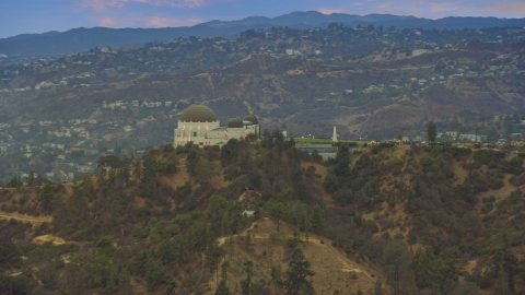 AX0158_006.0000241 - Aerial stock photo of Griffith Observatory at twilight against the hills, California