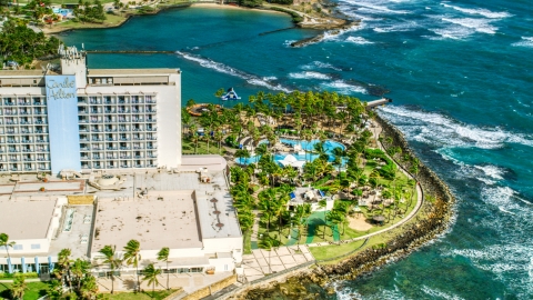AX101_005.0000000F - Aerial stock photo of Oceanside Caribbean resort hotel and pool area, San Juan, Puerto Rico