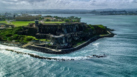 AX101_013.0000148F - Aerial stock photo of Historic fort along the coast of clear blue water, Old San Juan Puerto Rico