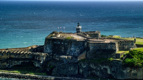 AX101_016.0000000F - Aerial stock photo of Historic fort along the coast resting on clear blue water, Old San Juan Puerto Rico