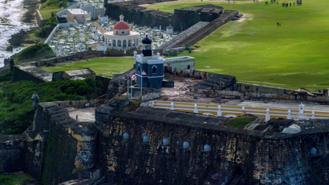 AX101_022.0000351F - Aerial stock photo of Historic fort and lighthouse on the coast, Old San Juan, Puerto Rico