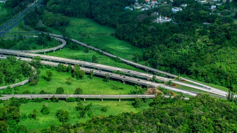 AX101_036.0000398F - Aerial stock photo of Highway cutting through rural area of grass and trees, Vega Alta, Puerto Rico 