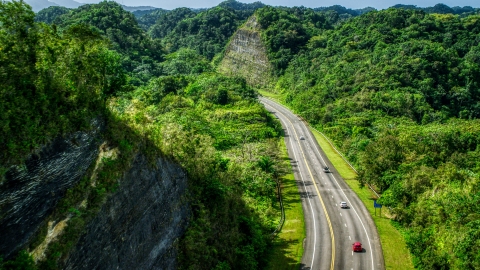 AX101_079.0000000F - Aerial stock photo of Highway with light traffic through lush green mountains, Karst Forest, Puerto Rico