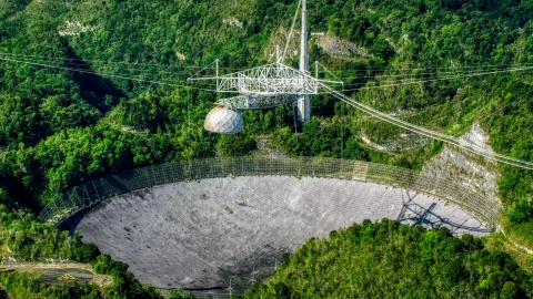 AX101_091.0000123F - Aerial stock photo of The Arecibo Observatory located in the lush green Karst forest of Puerto Rico