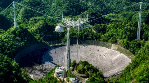 AX101_093.0000000F - Aerial stock photo of Arecibo Observatory in lush green Karst forest, Puerto Rico