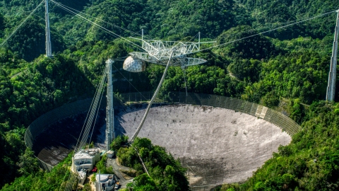 AX101_093.0000076F - Aerial stock photo of Arecibo Observatory in the green Karst forest, Puerto Rico