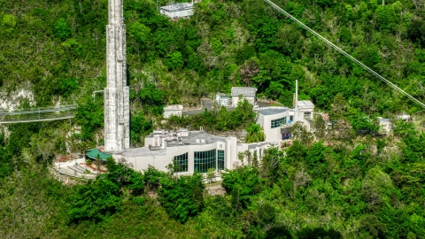 AX101_102.0000000F - Aerial stock photo of Arecibo Observatory building set among trees, Puerto Rico