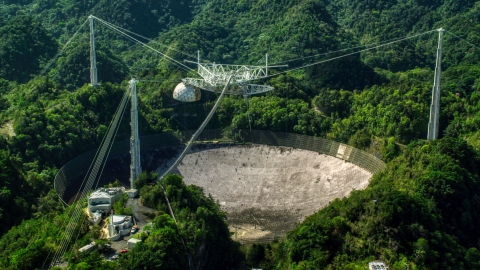 AX101_105.0000000F - Aerial stock photo of A view of the Arecibo Observatory surrounded by trees, Puerto Rico