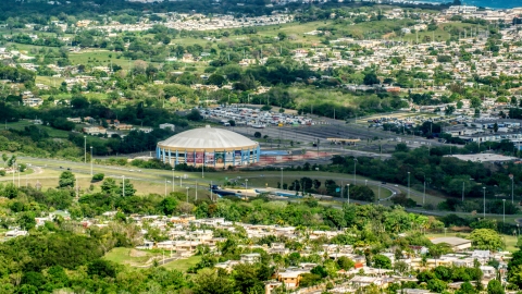 AX101_132.0000000F - Aerial stock photo of Coliseo Manuel Iguina sporting arena and homes, Arecibo, Puerto Rico