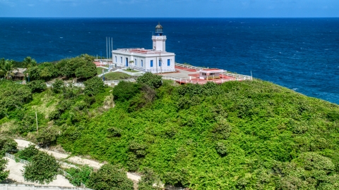 AX101_145.0000210F - Aerial stock photo of Arecibo Lighthouse and clear blue Caribbean waters, Puerto Rico 