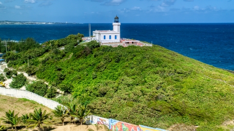 AX101_146.0000000F - Aerial stock photo of Arecibo Lighthouse on a hilltop by blue Caribbean waters, Puerto Rico