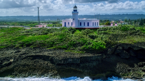 AX101_148.0000244F - Aerial stock photo of The Arecibo Lighthouse overlooking the island coast, Puerto Rico