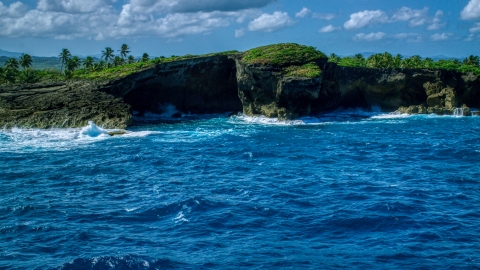 AX101_165.0000000F - Aerial stock photo of Coastal rock formation and crystal blue water, Arecibo, Puerto Rico 