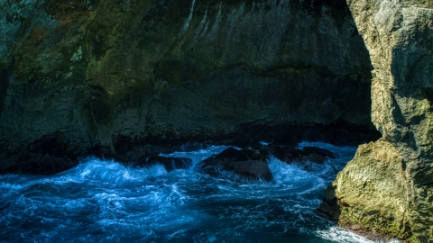 AX101_167.0000000F - Aerial stock photo of Churning water in a Caribbean sea cave, Arecibo, Puerto Rico