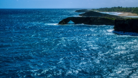 AX101_168.0000000F - Aerial stock photo of Arched rock formation in crystal blue water, Arecibo, Puerto Rico