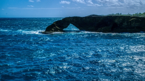 AX101_169.0000000F - Aerial stock photo of Arched rock formation and blue waters, Arecibo, Puerto Rico