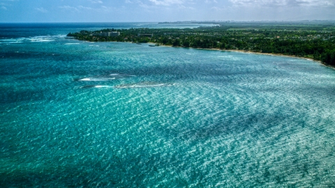 AX101_216.0000000F - Aerial stock photo of Caribbean island coastal community seen across blue water in Dorado, Puerto Rico