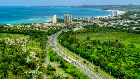 AX102_048.0000244F - Aerial stock photo of Highway 3 and a beach community with condo complexes in Luquillo, Puerto Rico 