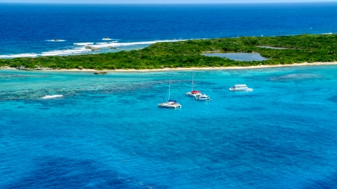 AX102_074.0000000F - Aerial stock photo of Catamarans in tropical blue waters near reefs and an island, Rada Fajardo, Puerto Rico