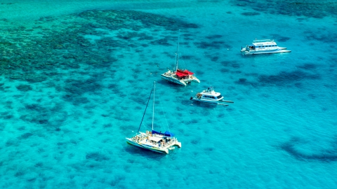 AX102_074.0000165F - Aerial stock photo of Catamarans in tropical blue Caribbean waters near reefs in Rada Fajardo, Puerto Rico