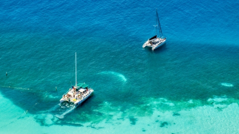 AX102_075.0000147F - Aerial stock photo of Catamarans in clear blue tropical waters, Rada Fajardo, Puerto Rico