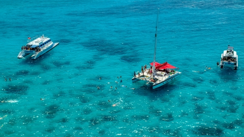 AX102_078.0000040F - Aerial stock photo of Snorkelers and catamarans in tropical blue waters, Rada Fajardo, Puerto Rico