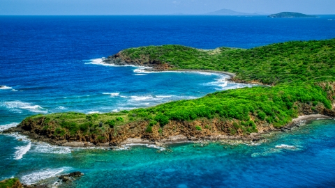 AX102_108.0000000F - Aerial stock photo of Rugged coastline of a tree covered Caribbean island in blue waters, Culebra, Puerto Rico