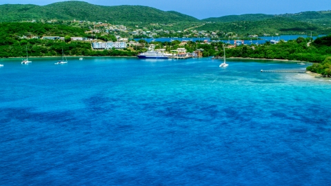 AX102_148.0000000F - Aerial stock photo of Ferry in the sapphire blue bay by a coastal town, Culebra, Puerto Rico 