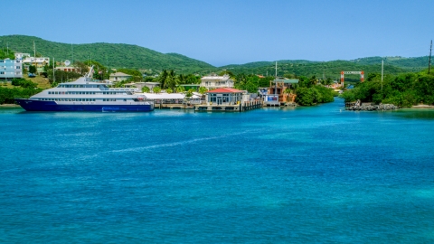 AX102_150.0000000F - Aerial stock photo of Ferry docked in sapphire waters by a waterfront town, and Culebra, Puerto Rico 