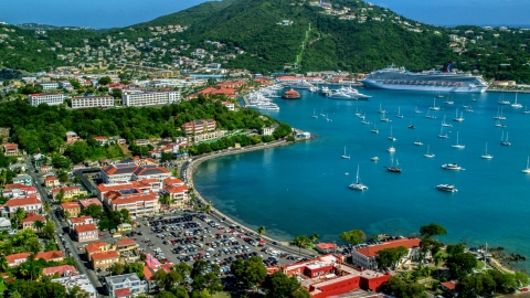 AX102_224.0000000F - Aerial stock photo of Sailboats and cruise ship in the harbor beside a Caribbean island town, Charlotte Amalie, St Thomas 
