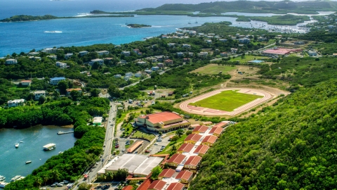 AX102_244.0000000F - Aerial stock photo of Island high school and track field near waterfront homes in East End, St Thomas, US Virgin Islands  