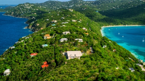 AX102_282.0000315F - Aerial stock photo of Oceanfront hillside island homes near sapphire blue Caribbean waters, Magens Bay, St Thomas 
