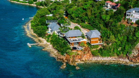 AX103_034.0000000F - Aerial stock photo of Oceanfront mansion beside turquoise blue Caribbean waters, Cruz Bay, St John