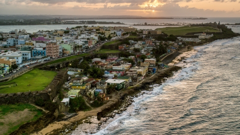 AX104_078.0000146F - Aerial stock photo of Oceanfront Caribbean homes, Old San Juan, Puerto Rico, sunset