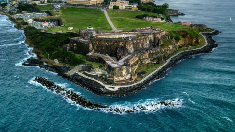 AX104_084.0000000F - Aerial stock photo of A view of Fort San Felipe del Morro along Caribbean blue waters, Old San Juan, twilight