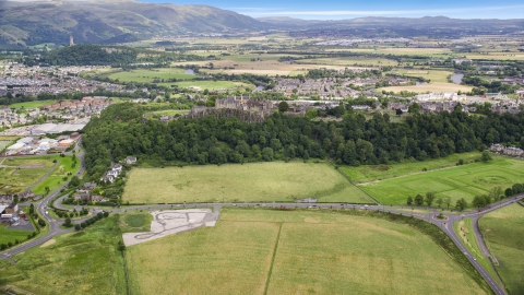 AX109_018.0000000F - Aerial stock photo of Stirling Castle, neighborhoods, and farmland, Scotland
