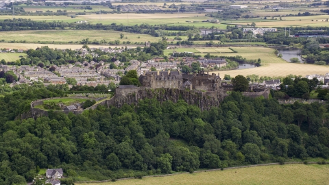AX109_019.0000084F - Aerial stock photo of A view of hilltop Stirling Castle among trees, Scotland