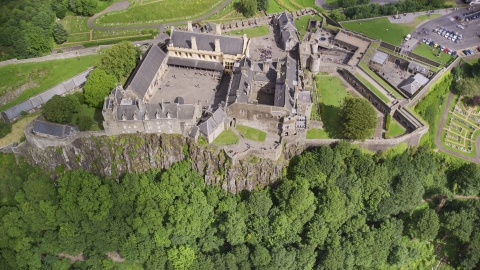 AX109_043.0000155F - Aerial stock photo of Iconic Stirling Castle and a tree covered hillside, Scotland