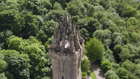 AX109_052.0000016F - Aerial stock photo of The top of historic Wallace Monument among trees, Stirling, Scotland