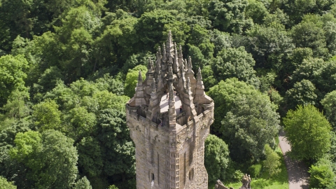 AX109_052.0000110F - Aerial stock photo of Top of iconic Wallace Monument near trees, Stirling, Scotland