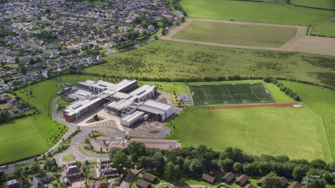 AX109_054.0000000F - Aerial stock photo of Wallace High School and soccer field, Stirling, Scotland
