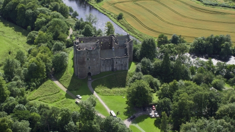 AX109_068.0000000F - Aerial stock photo of Iconic Doune Castle beside a river, Scotland