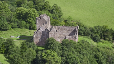AX109_070.0000000F - Aerial stock photo of Iconic Doune Castle nestled in trees, Scotland